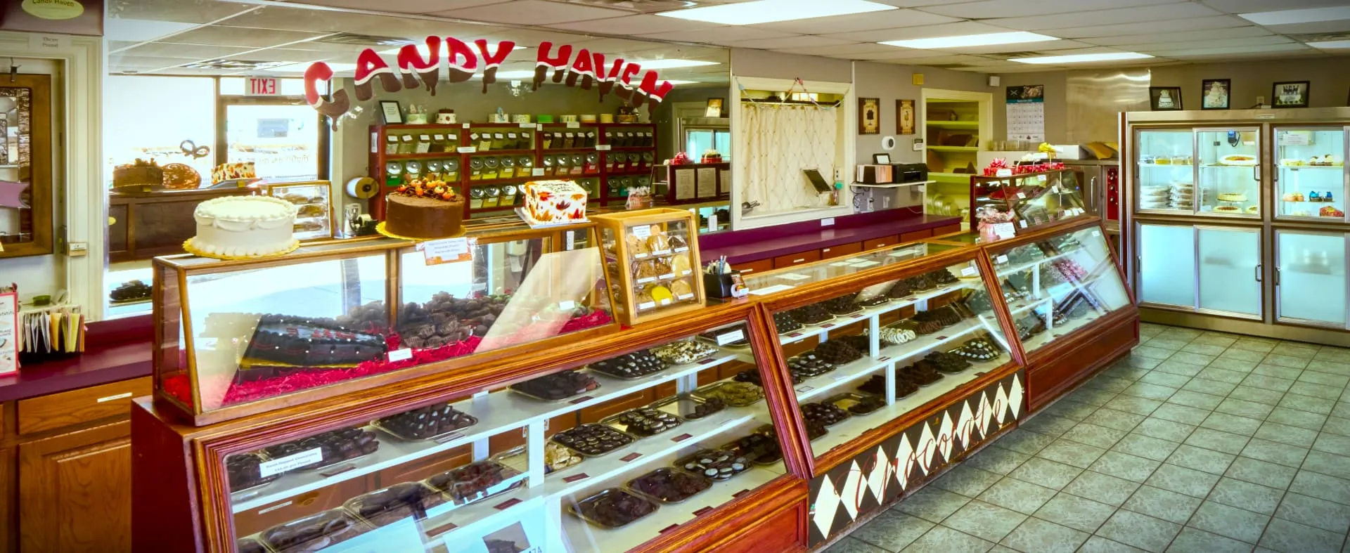 Candy Haven store interior featuring extensive chocolate display cases and sweet treats selection